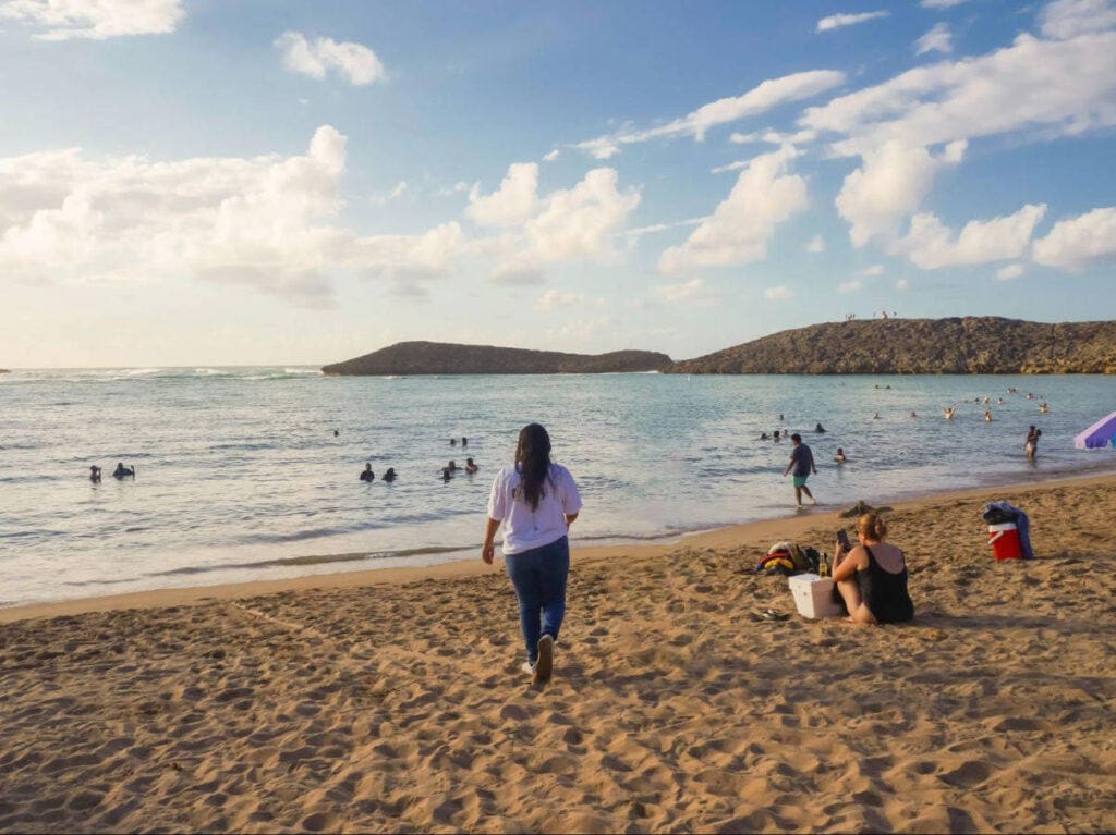 A guest walking the tide line at golden hour in Puerto Rico