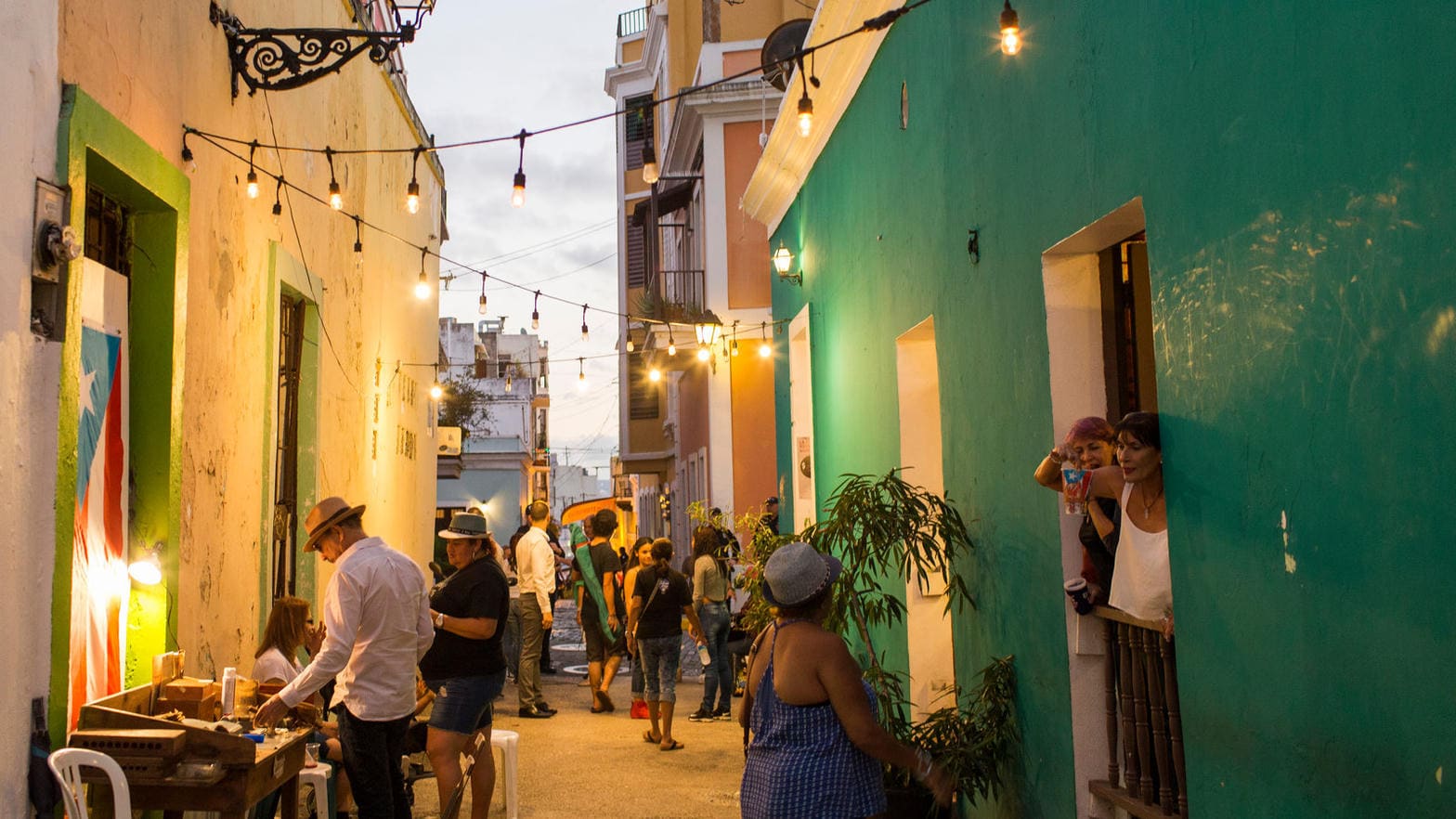 Old San Juan evening street with people and Puerto Rican flags